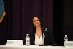 Women sitting at table with microphone.