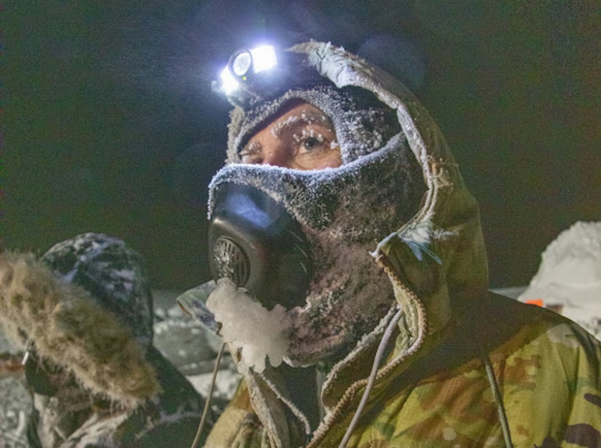 U.S. Air Force Chief Master Sgt. Jeremiah Wickenhauser, 133rd Contingency Response Team, uses a headlamp to work in the early afternoon in Crystal City, Canada.
