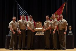 U.S. Marines pose for a photo with the 2023 Marine Corps Marksmanship Competition East pistol match trophy at the Base Theater on Marine Corps Base Camp Lejeune, North Carolina, March 17, 2023.  The winners of this year’s pistol match were Marine Corps Security Forces Training Company Team 1.