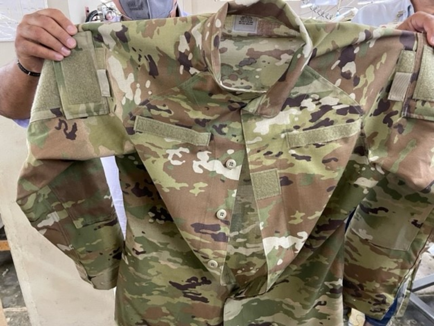 person holds up Army uniform