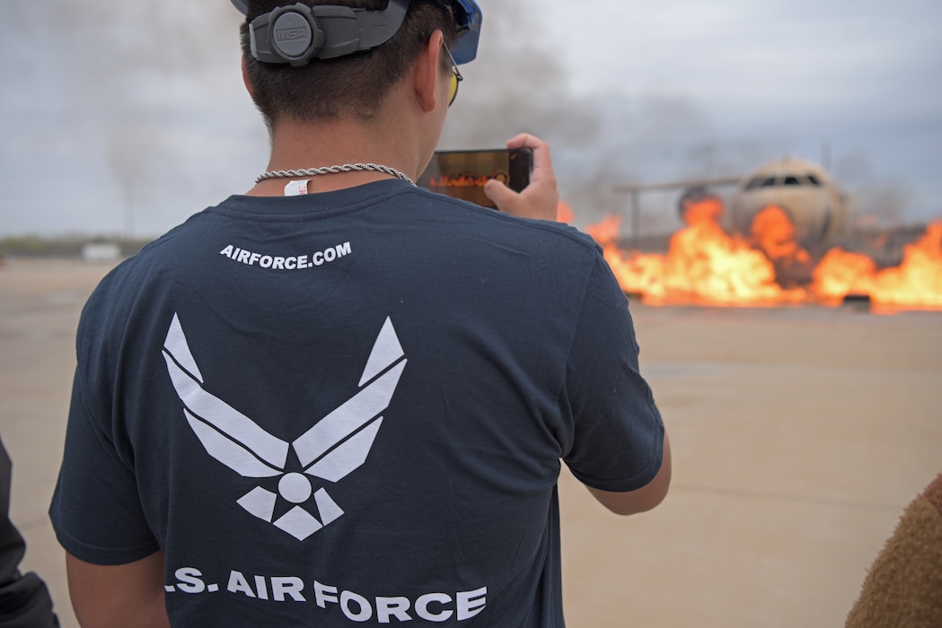 A local U.S. Air Force recruiting prospect, watches the aircraft fire simulation at the Louis F. Garland Department of Defense Fire Academy, Texas, March 29, 2023. The recruiting prospects toured the Fire Academy to see the different training blocks taught to firefighting students. (U.S. Air Force photo by Senior Airman Ashley Thrash)