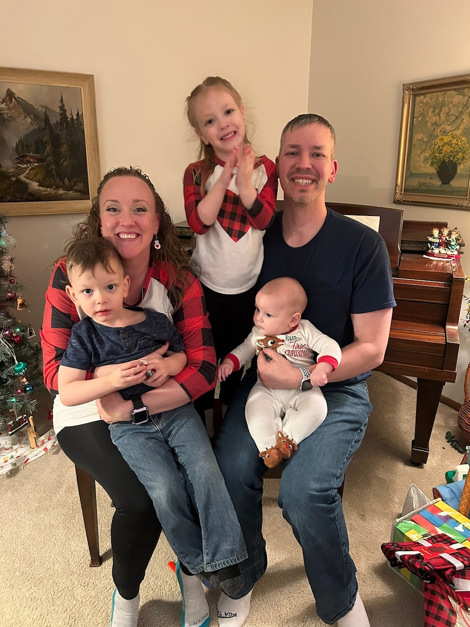 A man and woman poses for photo with three children.