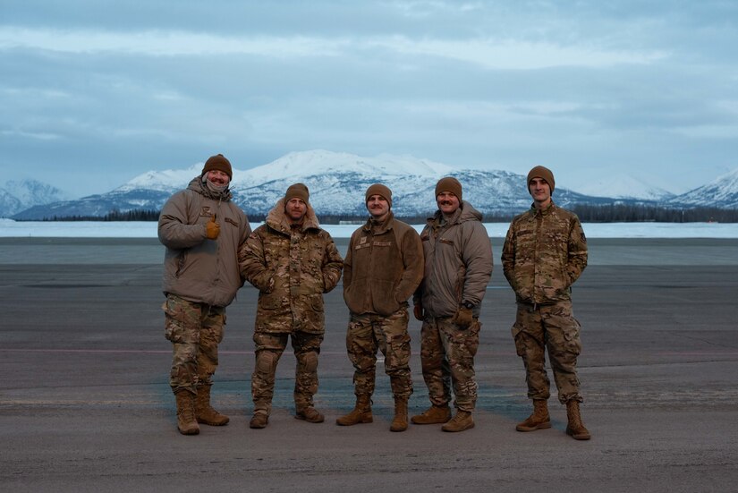 Photo of Airmen posing on a flight line