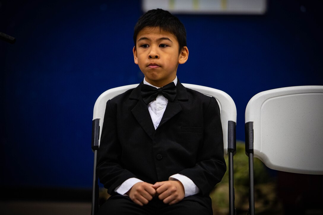 Nine-year-old Donald Ungott sits quietly waiting for the Alaska Heroism Medal ceremony to begin in the Gambell, Alaska, John Apangalook Memorial High School gymnasium March 28, 2023. Ungott was receiving a medal for deceased family member Pfc. Donald Ungott who was a member of the Alaska Army National Guard First Scout Battalion that mounted a rescue mission of 11 sailors who’s U.S. Navy P2V-5 Neptune plane was shot down on June 22, 1955, by two Russian MiG-15s.