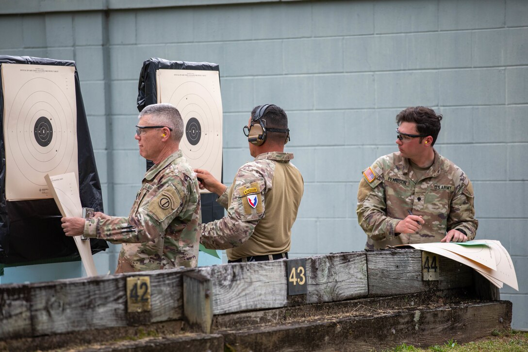 Command Sgt. Maj. Steven Slee, left, 85th United States Army Reserve Support Command, inspects his target during the 2023 U.S. Army Small Arms Championship at Fort Benning, GA. March. 17, 2023.