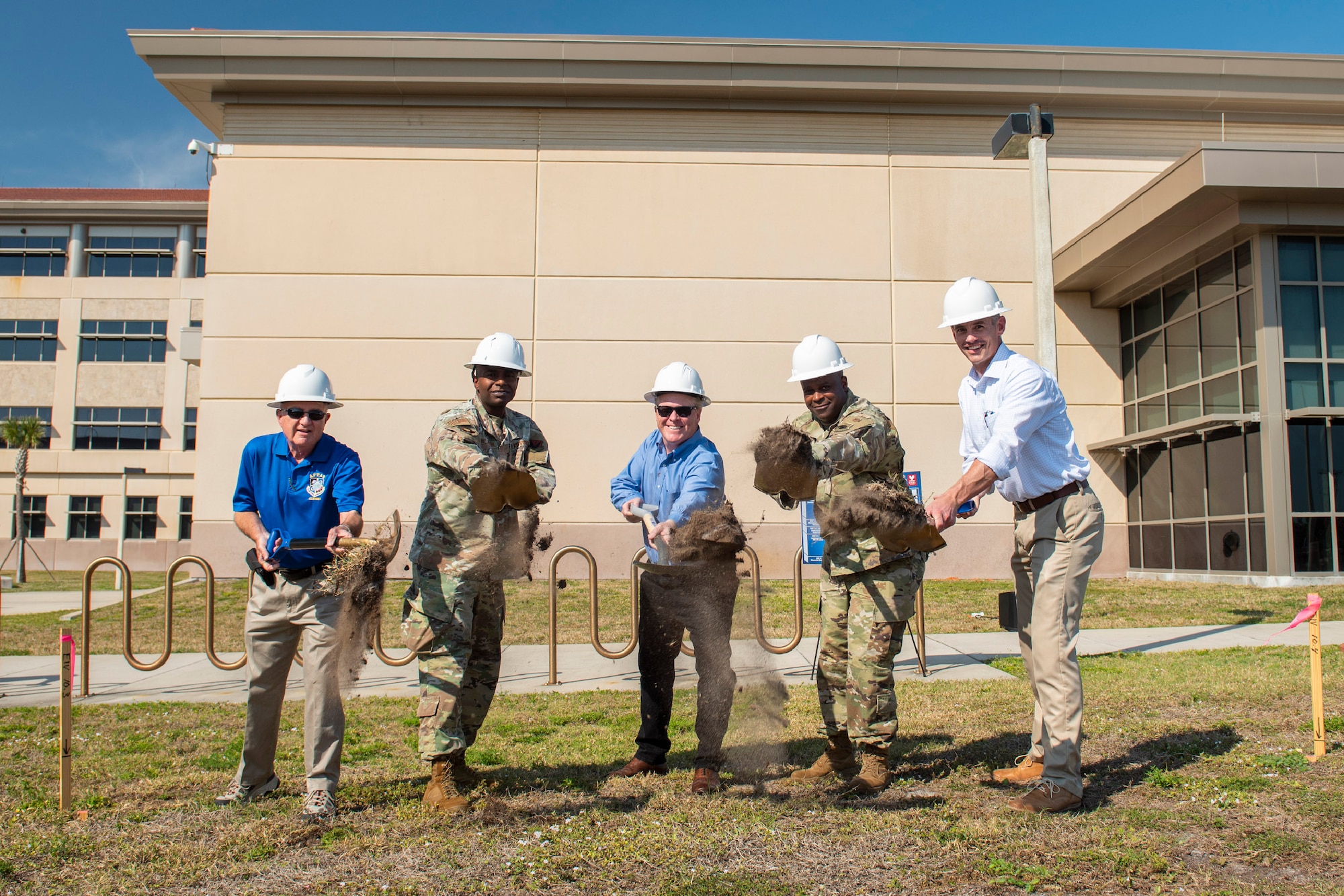 As ground is broken for a new memorial at the Air Force Technical Applications Center at Patrick Space Force Base, leaders symbolically toss shoveled earth where the memorial will be erected to honor fallen Airmen and civilians who once worked at the nuclear treaty monitoring center.  Pictured are:  Lou Seiler, AFTAC Memorial Corp.; Col James A. Finlayson, AFTAC commander; Todd Pokrywa, The Viera Company president; Col. Anthony Graham, SLD 45 vice commander; and Nick Crowe, Viera Builders executive vice president.  (U.S. Air Force photo by Matthew S. Jurgens)