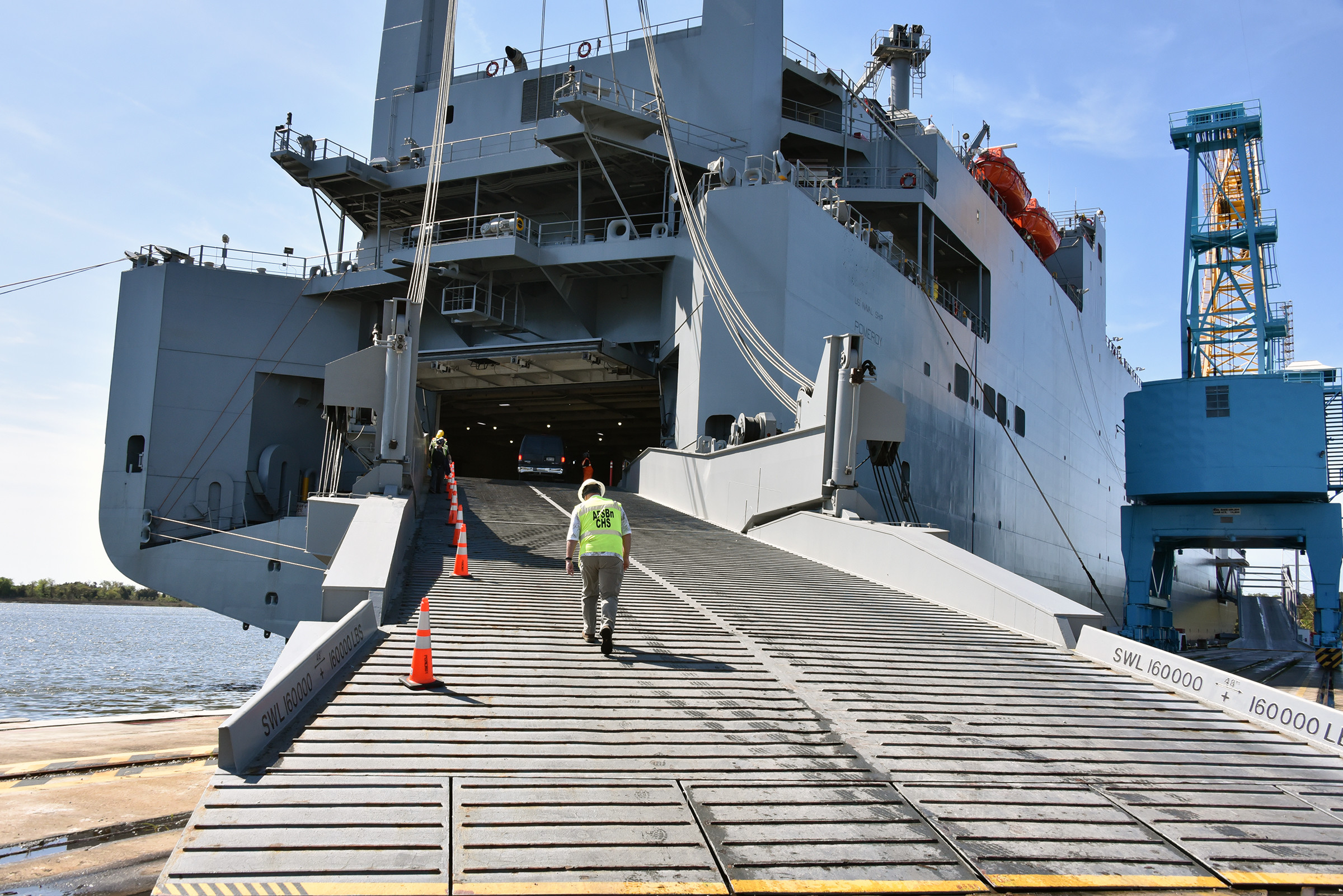 An Army Field Support Battalion-Charleston team member walks up the roll on/roll off ramp of the USNS Pomeroy (T-AKR 316) as the ship is docked and prepared to receive its load of military equipment and supplies as part of the Army Prepositioned Stocks, or APS, program. (Ellen Crown)