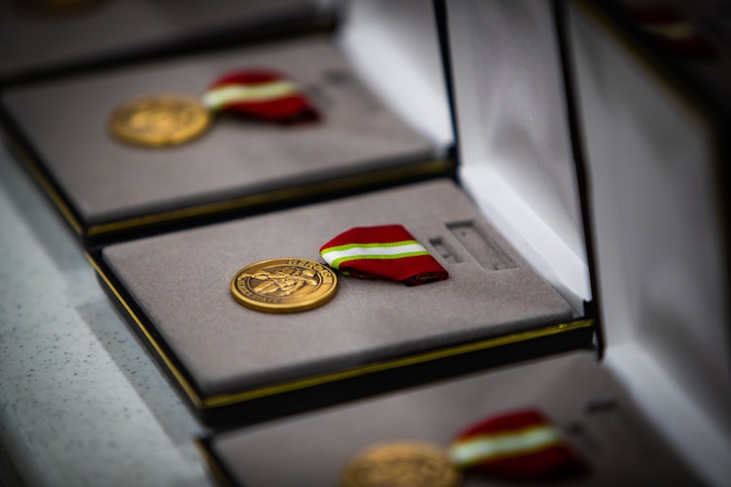 Three bronze medals with the inscription Heroism are displayed in cases.