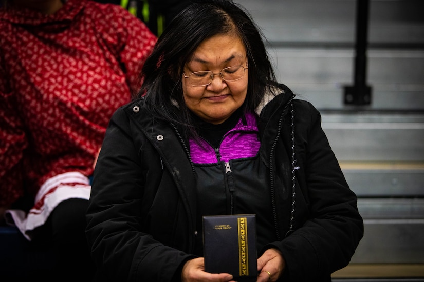 A woman looks at a medal.