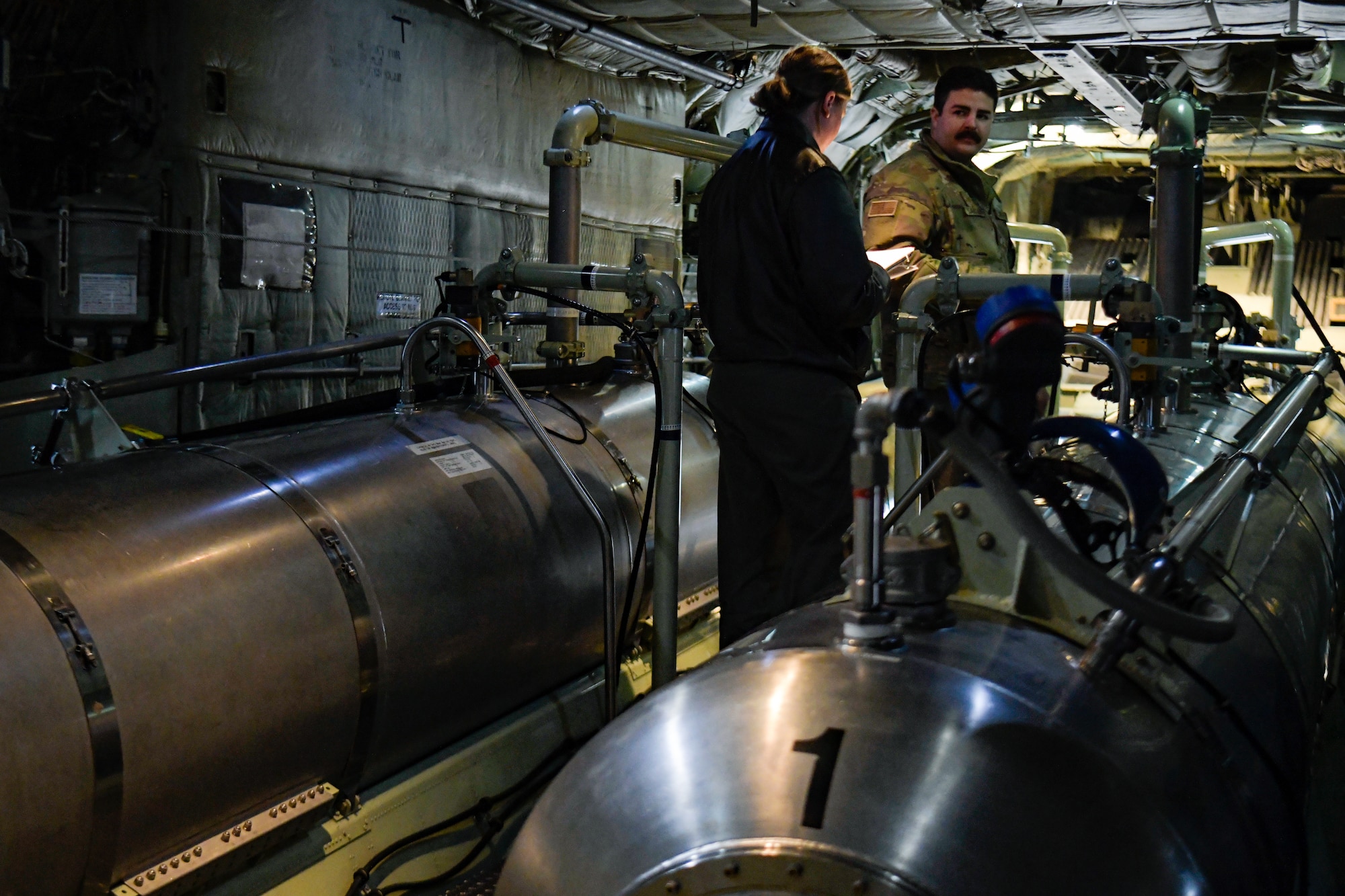 Master Sgt. Abby Stevenson and Tech. Sgt. Ethan Sanchez, aerial spray qualified loadmasters assigned to the 757th Airlift Squadron, run preflight checks on a modular aerial spray system aboard an aerial spray modified C-130H Hercules aircraft assigned to the 910th Airlift Wing, Youngstown Air Reserve Station, Ohio, on March 14, 2023, at Hill Air Force Base, Utah.