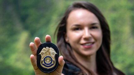 Female Army CID agent shows her special agent badge