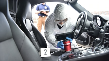 Army CID agent collecting evidence in car