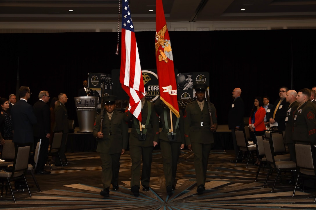 U.S. Marines with Headquarters Marine Corps, march in the colors for the third annual Information Awards Ceremony in Arlington, Virginia, April 14, 2022. The Marine Corps Association Information Awards Dinner, administered by the Deputy Commandant for Information, recognized 16 individual awards and 3 unit awards chosen from information communities including Intelligence, Command, Control, Communications and Computers (C4), Cyber, Psychological Operations (PSYOP), Space, Electromagnetic Spectrum Operations, Communication Strategy and Operations (COMMSTRAT) and Civil Affairs (CA). (U.S. Marine Corps photo by Lance Cpl. Christine Phelps)