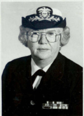 Black and white photo of woman in uniform posing for official photo