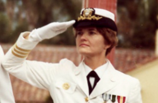 Vintage photo of woman in white uniform, Beth Coye saluting