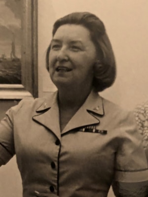 Black and white photo of sailors in uniform chatting, Alma Ellis on the right