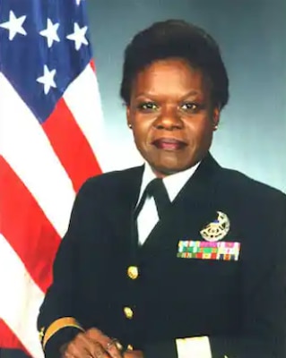 Lilian fishburn in middle with her grey blazer and white top smiling with other 2 admirals in their white uniform