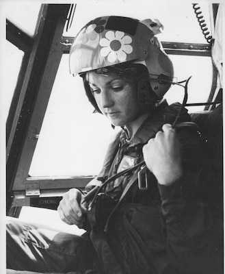 Black and white photo of woman in gear and helmet with one flower image on it