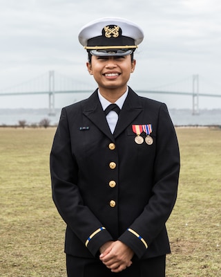 Smiling woman, Josia Pagler in uniform posing for the camera with bridge in the background