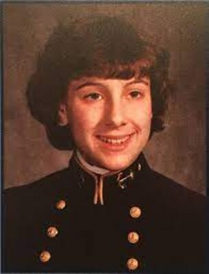 Smiling woman in uniform posing for official photo with brown abstract in the background