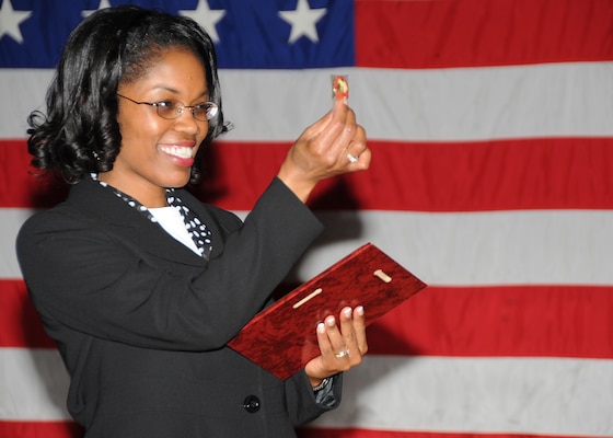 Woman in black suit pledges as she receives retirement flag