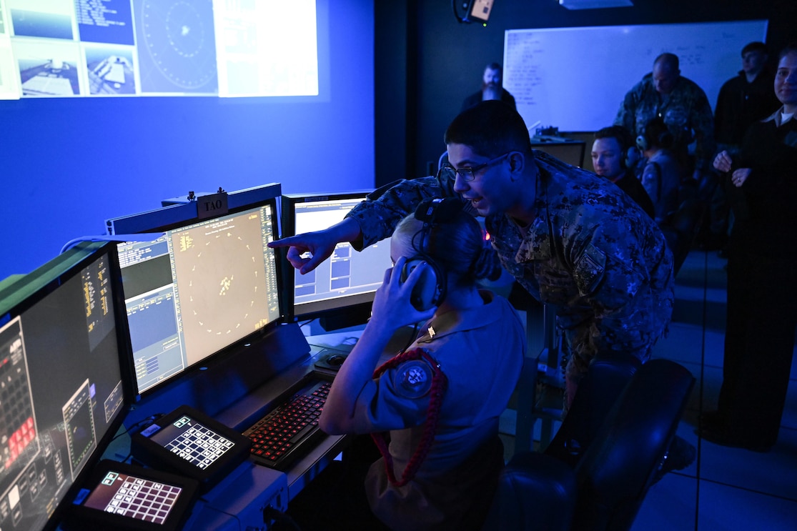 DAHLGREN, Va. (March 28, 2023) Surface Combat Systems Training Command (SCSTC) AEGIS Training and Readiness Center’s (ATRC) Lt. Tofik Benyaminov provides a training demonstration in the Reconfigurable Combat Information Center Trainer (RCT) to a cadet from Stafford High School’s Navy Junior Reserve Officer's Training Corps (NJROTC) during her visit to Naval Support Facility Dahlgren, March 28. The RCT is part of the Director, Surface Warfare’s (OPNAV N96) program of record, Surface Training Advanced Virtual Environment-Combat Systems (STAVE-CS), which was introduced in 2015 as a means to invest in training technologies, devices, and facilities to improve the effectiveness, efficiency, and availability of all surface training.