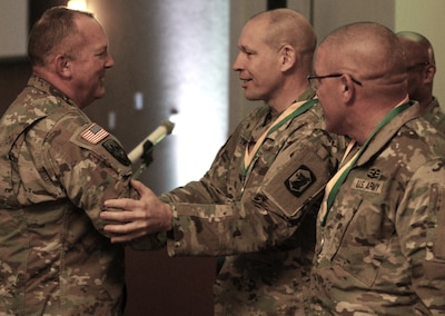 Col. Ron Bonesz, the Illinois Army National Guard's Director of Personnel (G-1) congratulates Col. Justin Towell, Commander of the 404th Maneuver Enhancement Brigade, after presenting him with the Military Police Regimental Association’s Order of the Marechaussee.