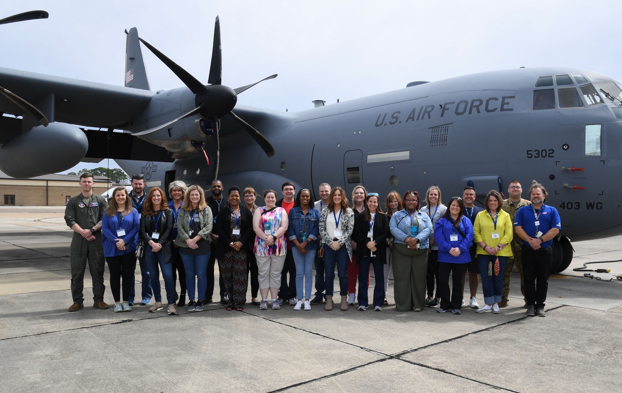 Members of the Association for Career and Technical Education pose for a group photo in front of a WC-130 Hercules aircraft for a tour at Keesler Air Force Base, Mississippi, March 29, 2023.