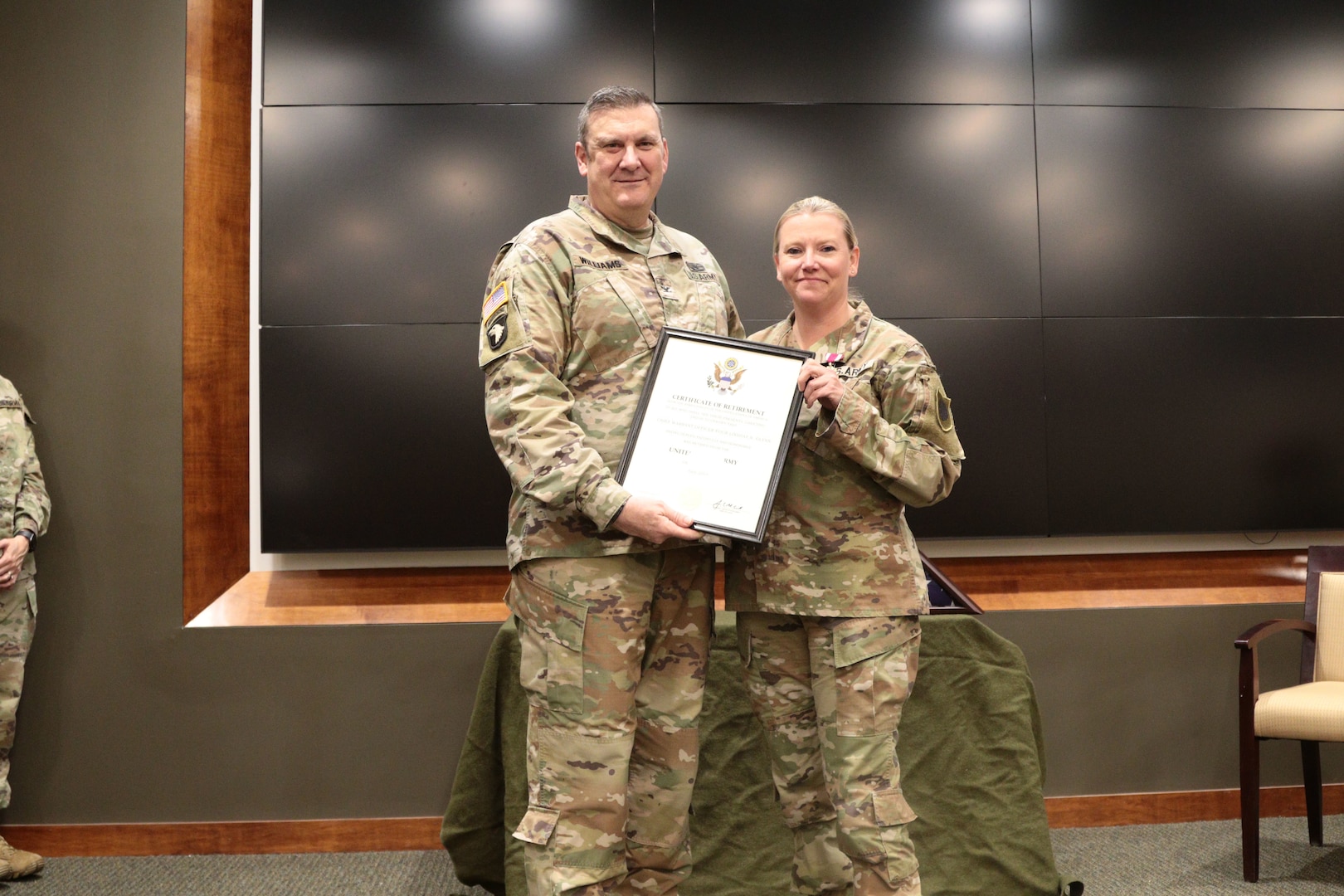 Col. Lenny Williams, Chief of Staff for the Illinois Army National Guard, presents Chief Warrant Officer 4, Lindsay Glynn her certificate of retirement Mar. 4, 2023.