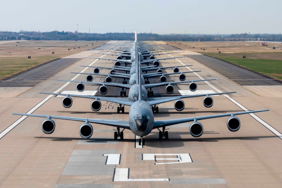 Aircraft line up in formation on a tarmac.