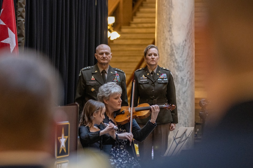 Gen. Edward M. Daly, U.S. Army Materiel Command commanding general, and Col. Paige M. Jennings, U.S. Army Financial Management Command commander, listen as Jennings’ cousin, Paula Fairchild, and niece, Adelyn Tiffin, play the Star-Spangled Banner during Jennings promotion ceremony at the Indiana Statehouse in Indianapolis Feb. 17, 2023. Jennings, a native of Missoula, Montana, began her military career in 1995 after commissioning into the Finance Corps as a distinguished military graduate of the University of Montana’s Grizzly Battalion Army Reserve Officer Training Corps program. (U.S. Army photo by Mark R. W. Orders-Woempner)