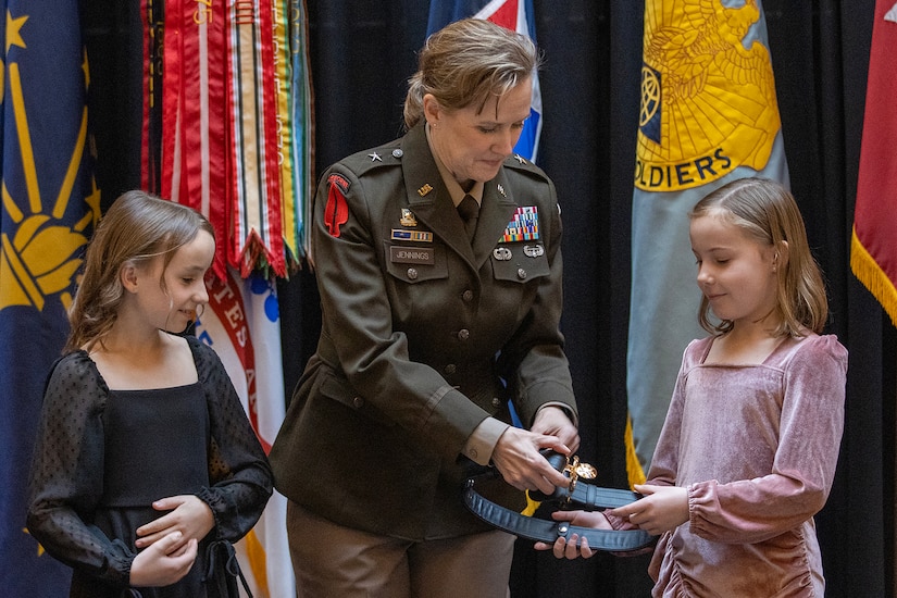 Adelyn and Brynn Tiffin present their aunt, Brig. Gen. Paige M. Jennings, U.S. Army Financial Management Command commanding general, with her general officer’s belt during Jenning’s promotion ceremony at the Indiana Statehouse in Indianapolis Feb. 17, 2023. The history of the belt dates to World War II when Army Chief of Staff Gen. George C. Marshall directed that the belt be issued to all general officers for wear when carrying a sidearm, except in combat. (U.S. Army photo by Mark R. W. Orders-Woempner)