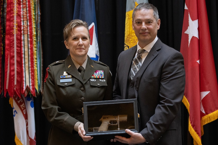 Larry Jennings presents his wife, Brig. Gen. Paige M. Jennings, U.S. Army Financial Management Command commanding general, with her general officer’s sidearm during her promotion ceremony at the Indiana Statehouse in Indianapolis Feb. 17, 2023. A long-standing U.S. Army tradition is the issuing of a sidearm to general officers. Internally and externally the general officer sidearm is no different to the M18 entering general service with the Army, except for the serial numbers beginning with “G” and “O.” (U.S. Army photo by Mark R. W. Orders-Woempner)