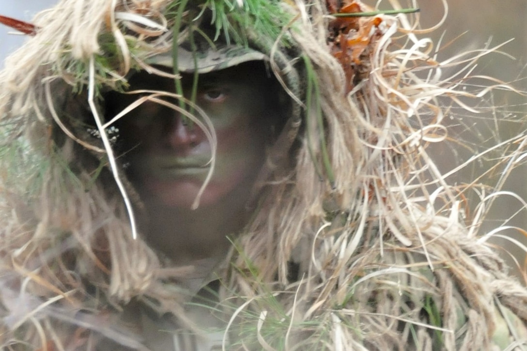 A soldier prepares for the mission wearing camouflaging makeup.