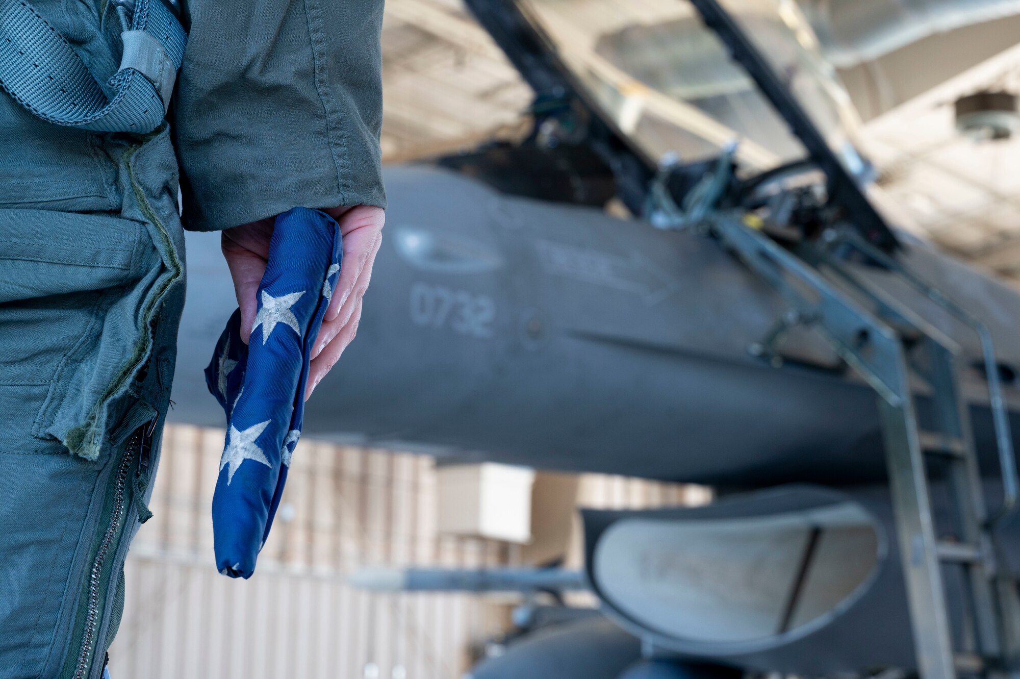 U.S. Air Force Maj. Matthew Jerrell, 314th Fighter Squadron instructor pilot, carries an American flag to an F-16 Viper at Holloman Air Force Base, New Mexico, March 27, 2023.