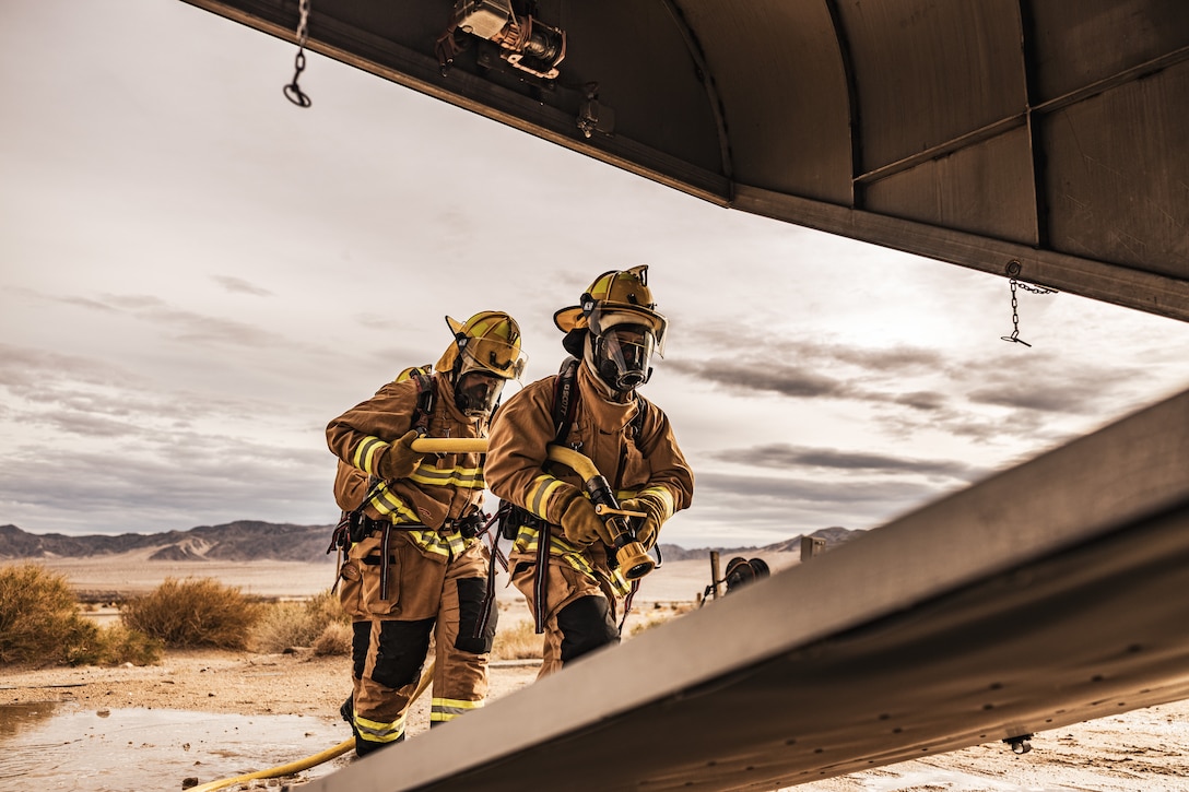U.S. Marine Corps aircraft rescue and firefighting specialist with Air Ground Support Detachment, Marine Corps Air Ground Combat Center, enter a downed aircraft during a simulated mass casualty incident at MCAGCC, Twentynine Palms, California, March 14, 2023. AGSD and the MCAGCC Fire Department teamed up to test their preparedness to prevent the loss of life in real emergencies.