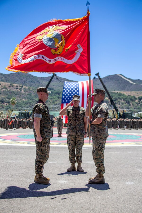 U.S. Marine Corps Col. Coby Moran, right, the outgoing commanding officer of the School of Infantry - West, holds the battalion colors during a change of command ceremony at SOI-West on Marine Corps Base Camp Pendleton, California, June 24, 2022. During the ceremony, Moran relinquished command of SOI-West to Col. Seth MacCutcheon. Moran is a native of Seattle. (U.S. Marine Corps photo by Cpl. Alison Dostie)