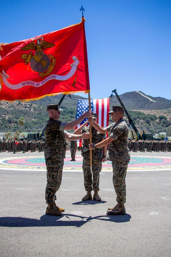 U.S. Marine Corps Col. Coby Moran, right, the outgoing commanding officer of the School of Infantry - West, passes the battalion colors to Col. Seth MacCutcheon, the incoming commanding officer of SOI-West, during a change of command ceremony at SOI-West on Marine Corps Base Camp Pendleton, California, June 24, 2022. Moran reported to SOI-West in July of 2020. MacCutcheon is reporting from U.S. Marine Forces Pacific. Moran is a native of Seattle; MacCutcheon is a native of Fort Lauderdale, Florida. (U.S. Marine Corps photo by Cpl. Alison Dostie)