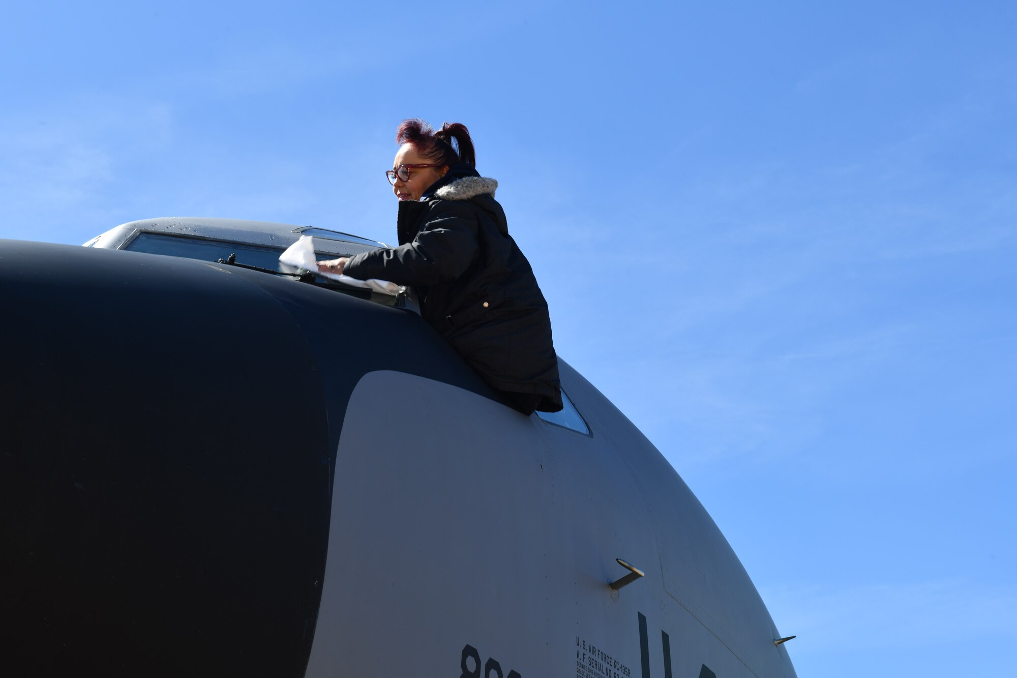 Victoria Cerda, 97th Aircraft Maintenance Squadron aircraft attendant, cleans the windows of a KC-135 Stratotanker at Altus Air Force Base, Oklahoma, March 23, 2023. Aircraft attendants perform general ground maintenance on the aircraft and assist with launch and recovery. (U.S. Air Force photo by Airman 1st Class Miyah Gray)