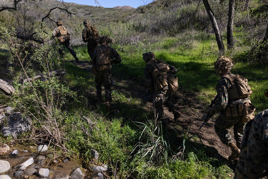U.S. Marines with Infantry Marine Course 2-23, Infantry Training Battalion, School of Infantry-West, move through a creek to their assault position during a fire and maneuver range at Marine Corps Base Camp Pendleton, California, Jan. 24, 2023. IMC is the Marine Corps’ 14-week entry-level training course for enlisted infantry Marines. (U.S. Marine Corps photo by Cpl. Willow Marshall)