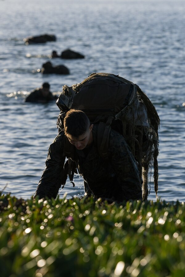 U.S. Marine Pfc. Joseph Pisani, a student with Infantry Marine Course 1-23, Infantry Training Battalion, School of Infantry - West, exits the water after an amphibious insert at the Del Mar Boat Basin as part of the final training exercise on Marine Corps Base Camp Pendleton, California, Jan. 23, 2023.  IMC is the Marine Corps’ 14-week infantry training course designed to make better trained and more lethal entry-level Marines. (U.S. Marine Corps photo by Lance Cpl. Earik Barton)