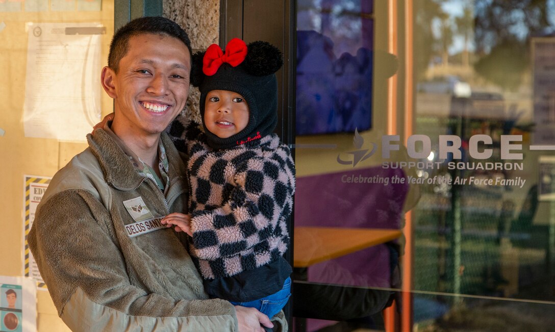 Senior Airman Justin Delos Santos, 412th Medical Group, poses for a photo with his daughter at the child development center. The CDC provides activities and programs which support children’s social, emotional, physical and intellectual development. Op-quality childcare has been a priority at Edwards for many years as evidenced by the quality facilities and the wide variety of programs offered and the recent expansion of available slots for children. (Air Force photo by Todd Schannuth)