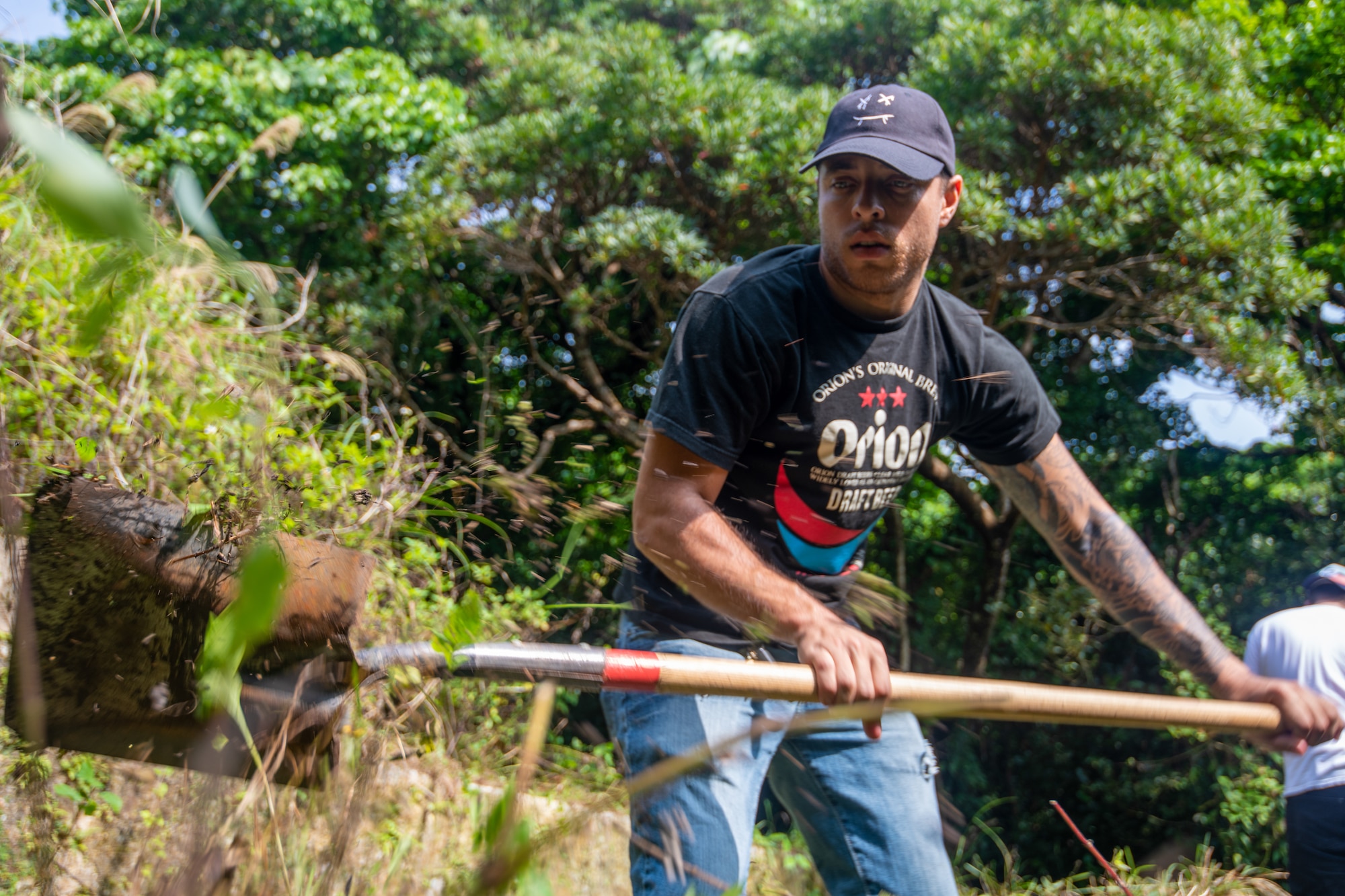 Airman 1st Class Austyn Colon using a shovel to get rid of roots.