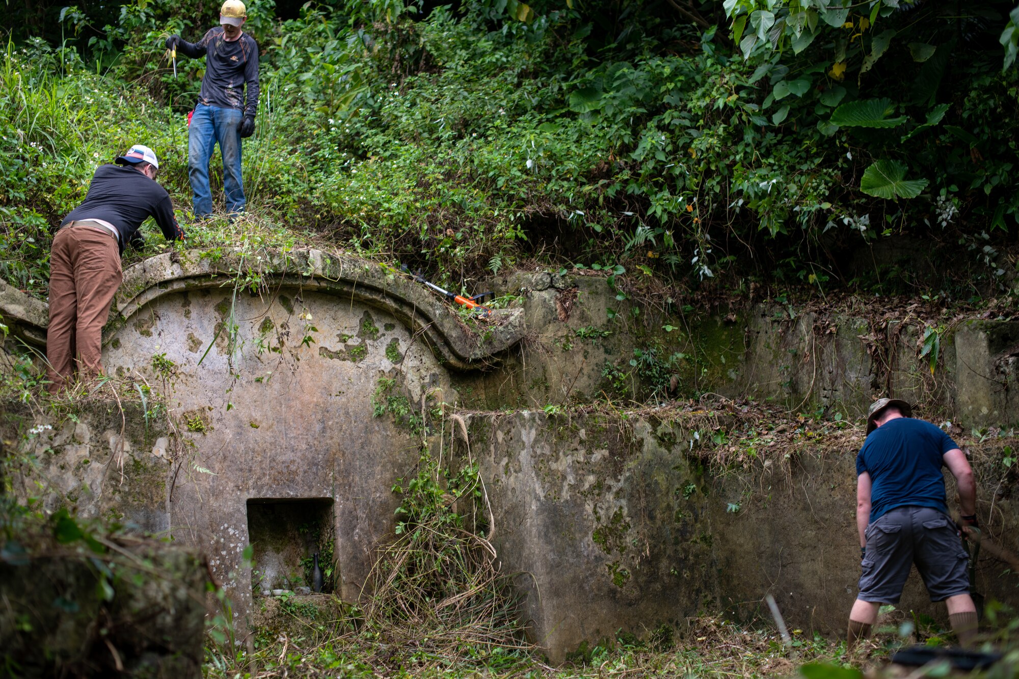 Airmen working together to clean one of the Okinawan, ancestral tombs.