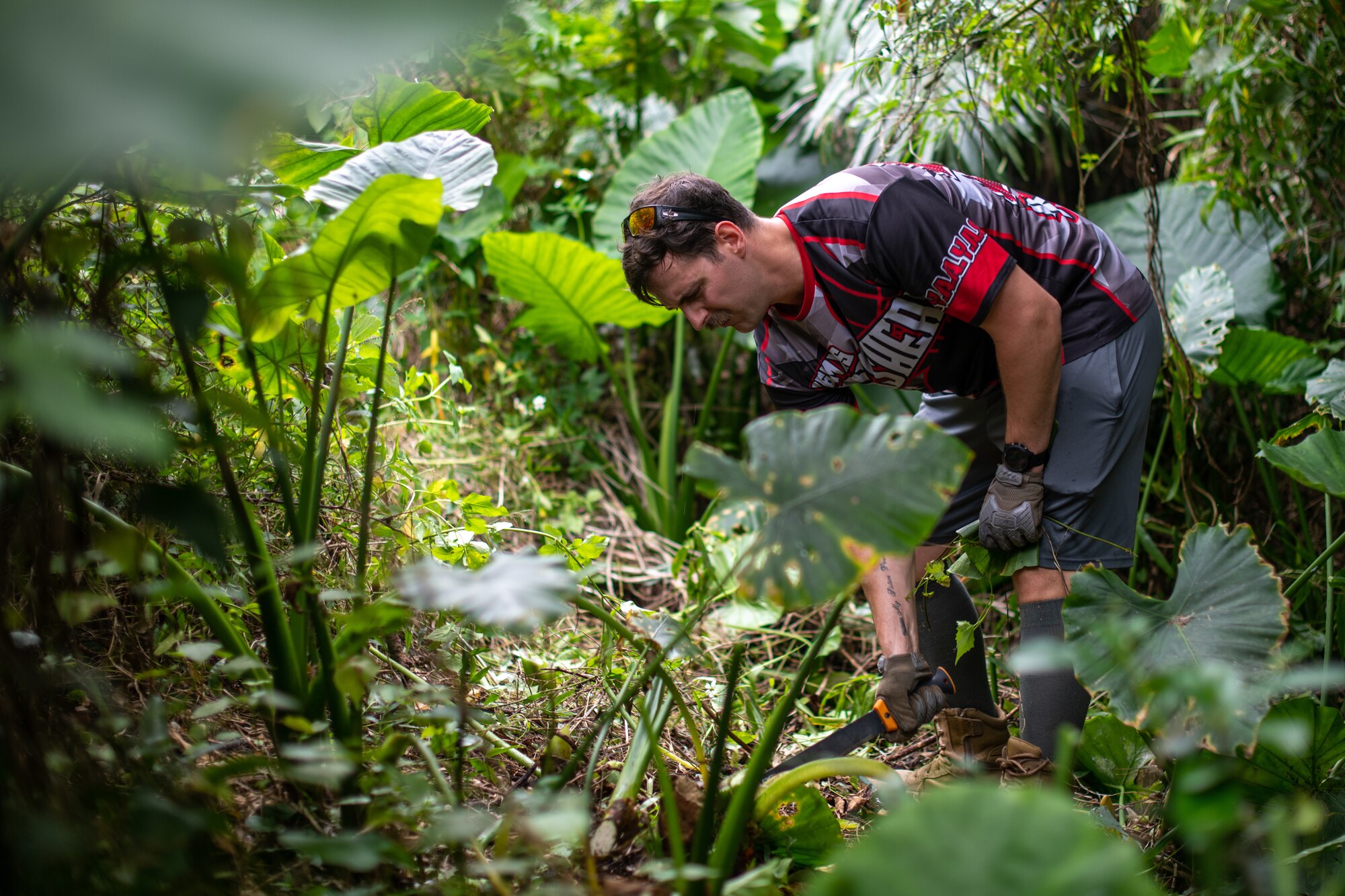U.S. Air Force Staff Sgt. clearing a path of jungle vegetation.