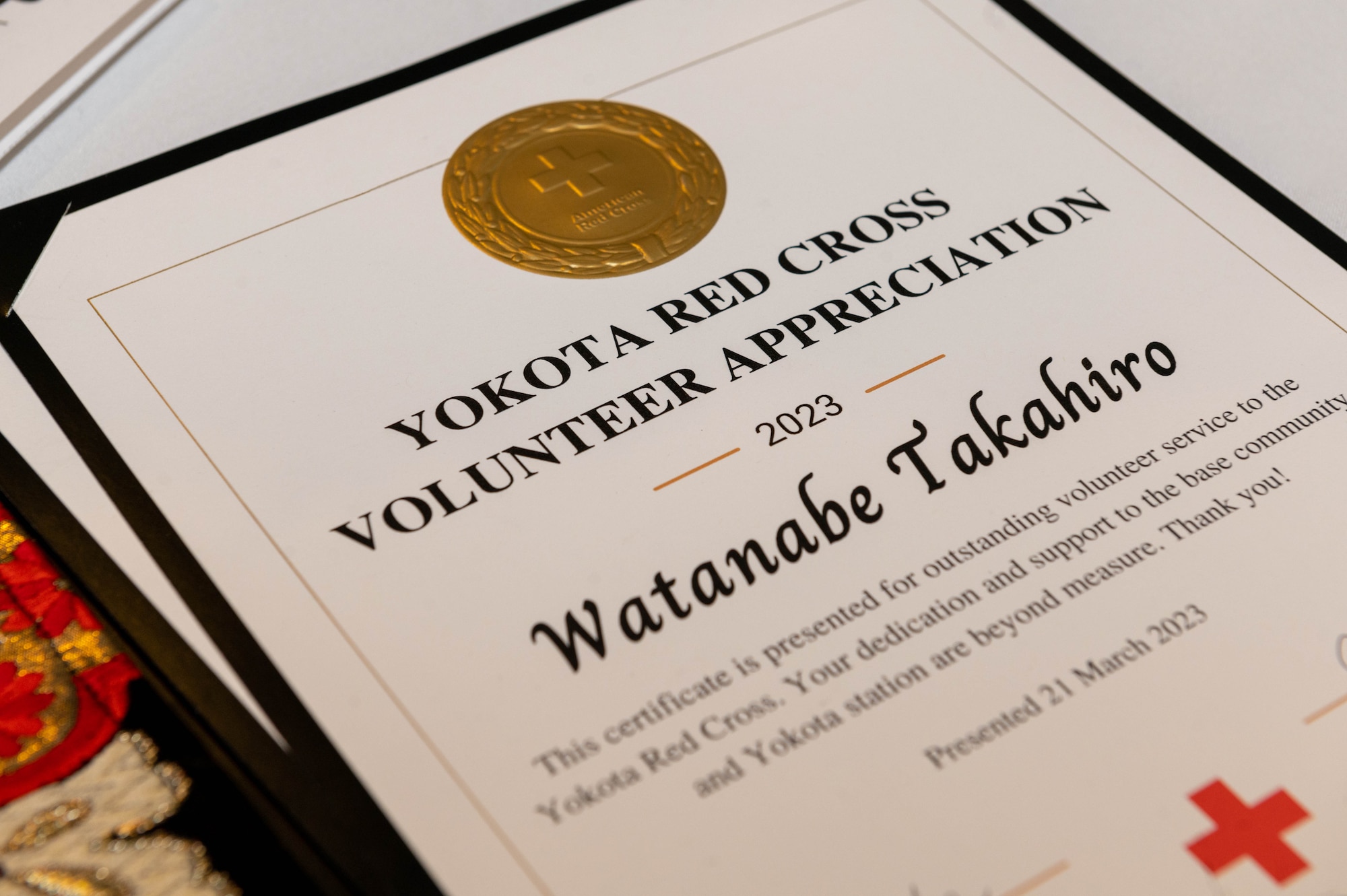 A certificate of appreciation rests on a table.