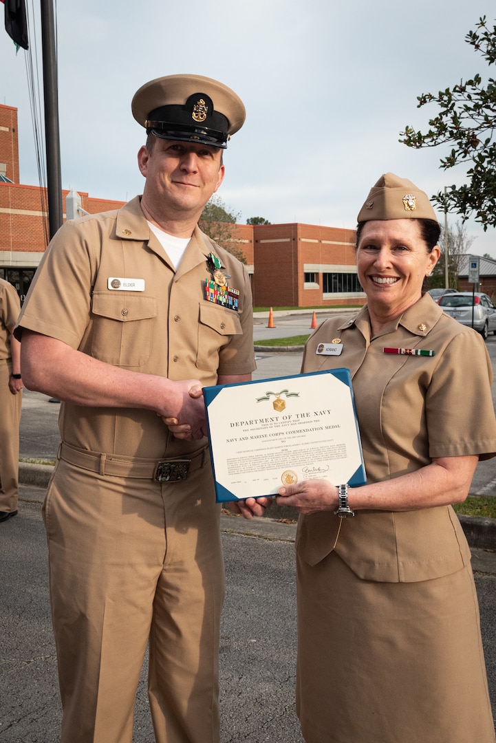 Naval Health Clinic Cherry Point celebrated the service and leadership of Chief Hospital Corpsman Adam Elder during a ceremony held Friday, March 30 aboard Marine Corps Air Station Cherry Point, North Carolina.
Elder served at the clinic from September 2021 to April 2023 as the Senior Enlisted Leader of the facility’s Directorate of Surgical Services.  He led 33 staff in completion of more than 340 surgeries while increasing the team’s capabilities and guided 13 Sailors in the performance of military honors at more than 100 funerals.
He received the Navy and Marine Corps Commendation Medal from Navy Capt. Elizabeth Adriano, Commander of Naval Health Clinic Cherry Point.