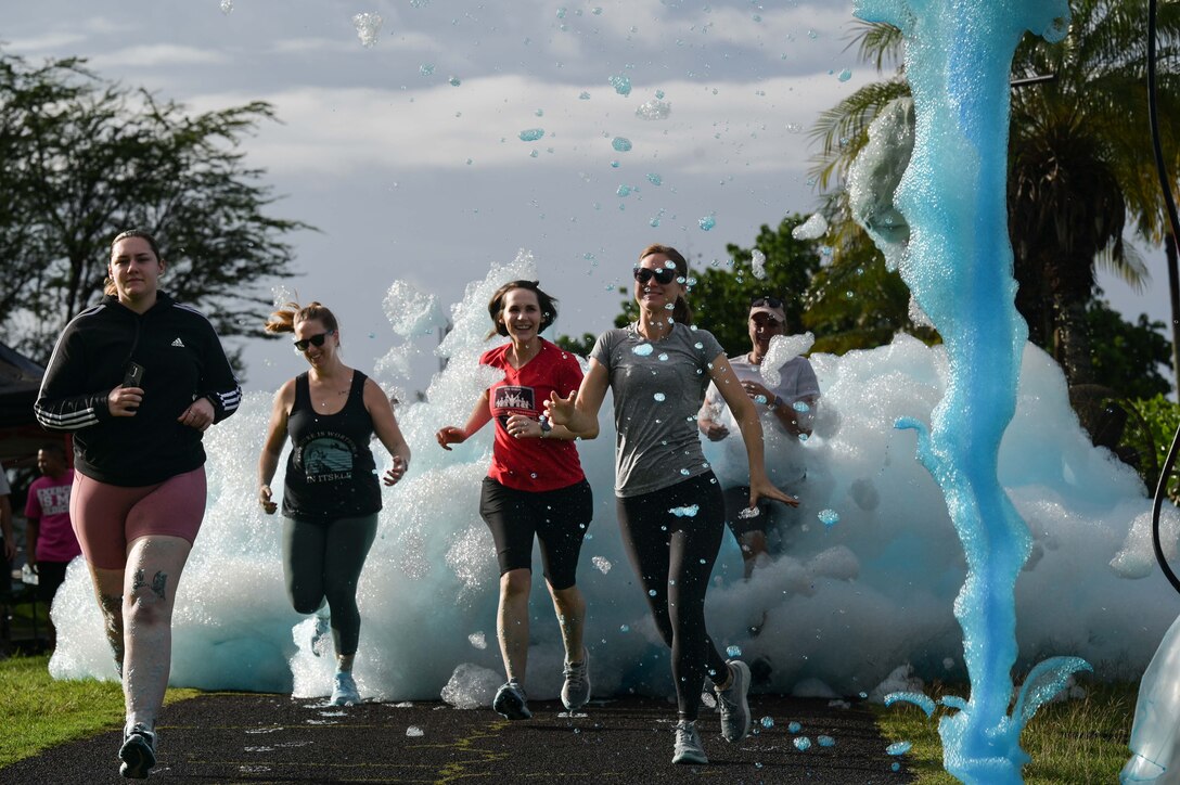 Five runners participate in a foam run.