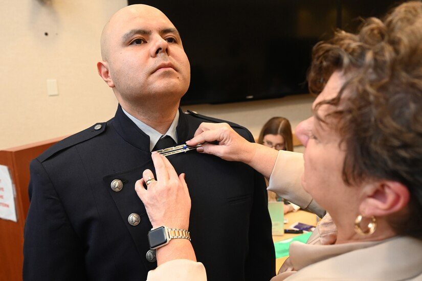 A guardian gets his clothes measured for a uniform.