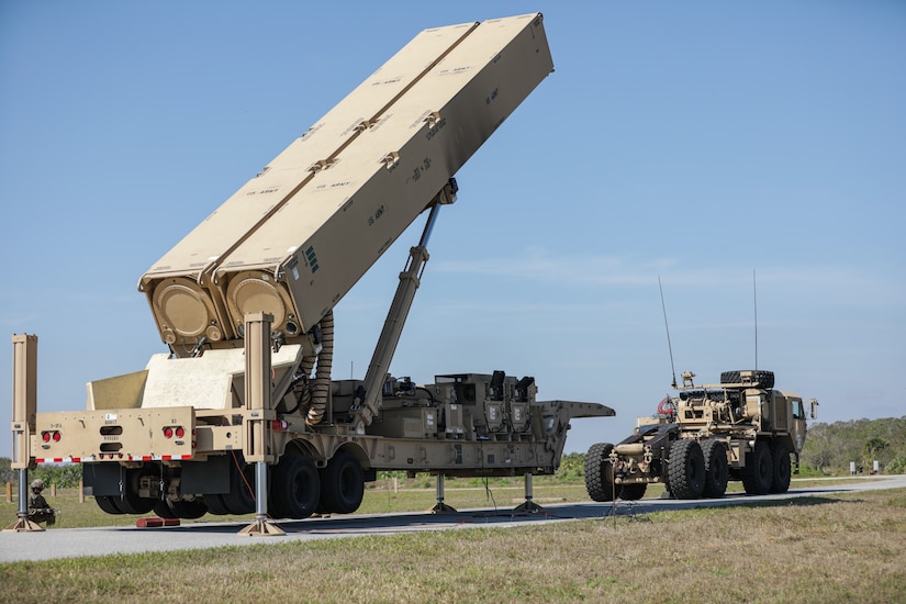 A large weapon launching system sits on a road.